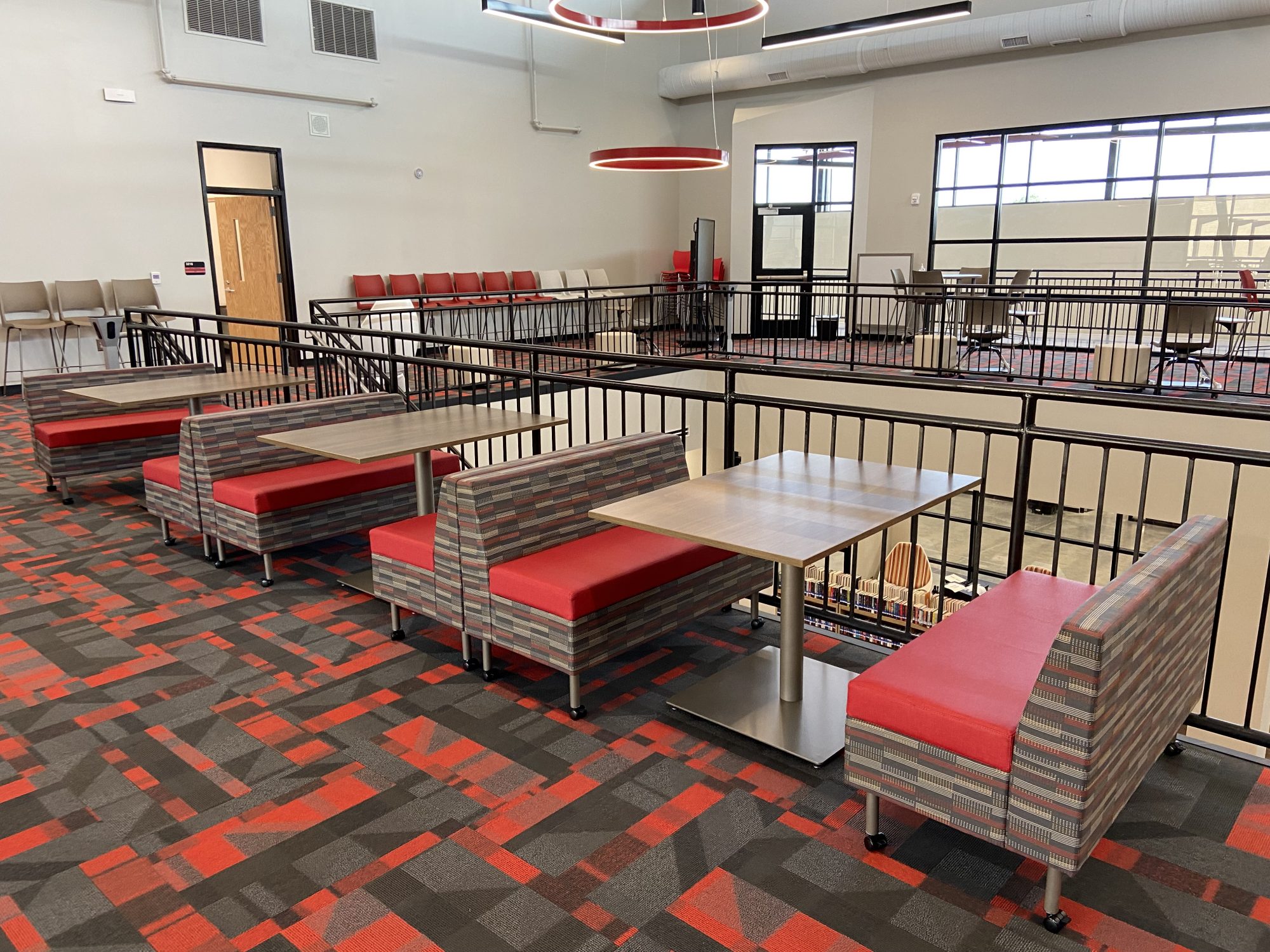 red booth style tables against a black railing
